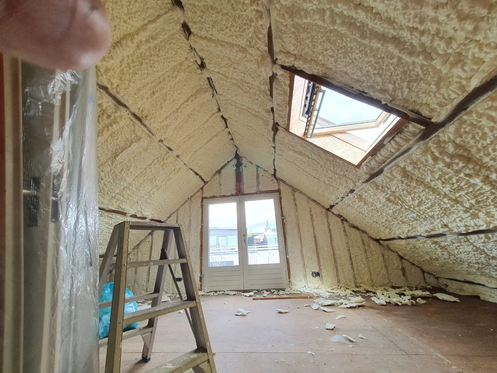 Zolder met dakschild en kopgevel volledig geïsoleerd met sprayfoam, met dakraam en openslaande deuren